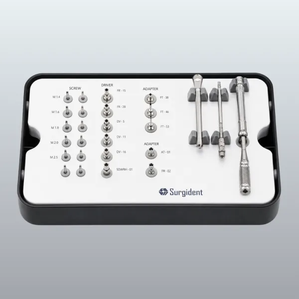 Dental implant instrument tray with screws, drivers, adapters, and a handle set labeled Surgident on a white tray.