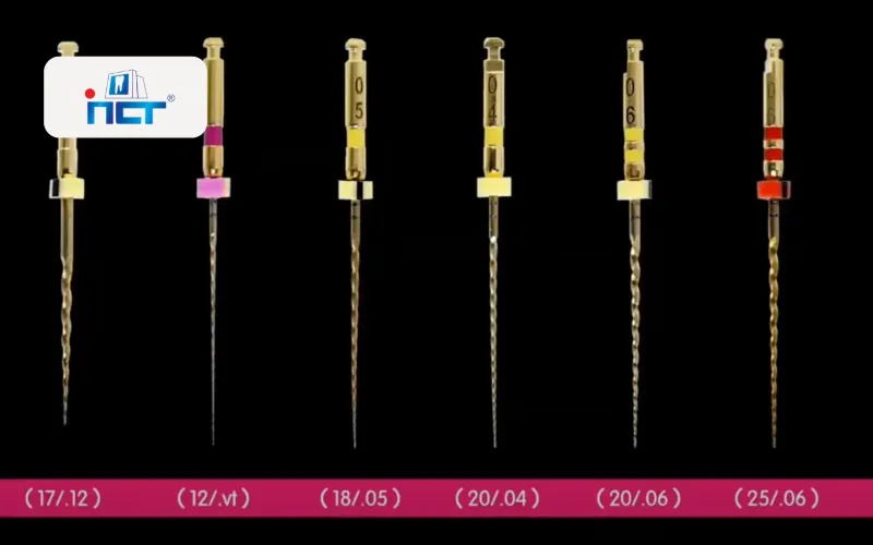 Row of six gold-tone precision devices with colored bands (pink, yellow, and red) against a black background, numbers etched on each, with a pink date bar at bottom.